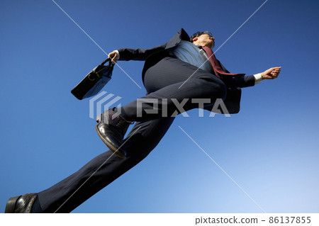 一個穿著西裝的商人在藍天上奔跑 86137855