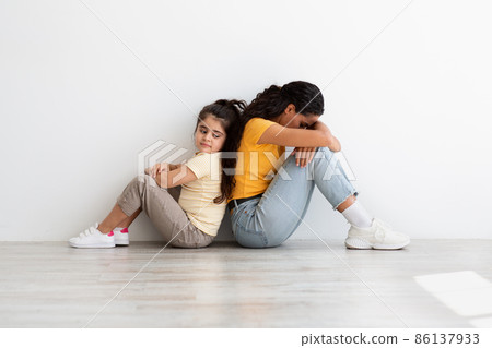 Motherhood Challenges. Upset Mom Sitting Back To Back With Daughter After Argument Motherhood Challenges. Upset Mom Sitting Back To Back With Daughter After Argument 86137933