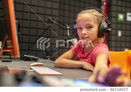 Concentrated tranquil girl sitting in the broadcasting studio 86138037