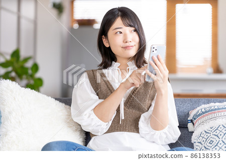 A young woman operating a smartphone A young woman operating a smartphone 86138353