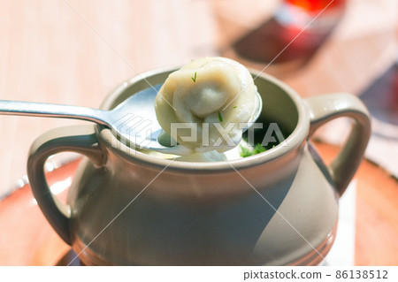 Dumplings in a clay pot, serving dishes in a street cafe, close-up 86138512