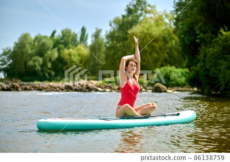 A woman sitting on a kayak and doing stretching 86138759