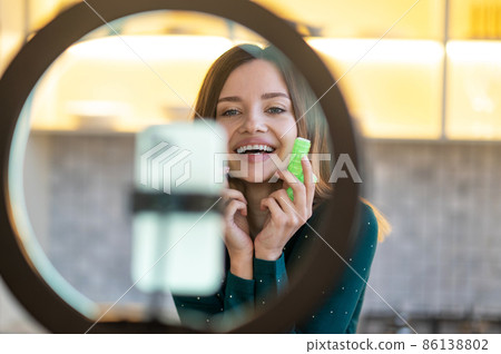 Smiling young woman showing tips on hairstying with curlers Smiling young woman showing tips on hairstying with curlers 86138802