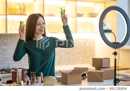 Smiling young woman showing tips on hairstying with curlers Smiling young woman showing tips on hairstying with curlers 86138804