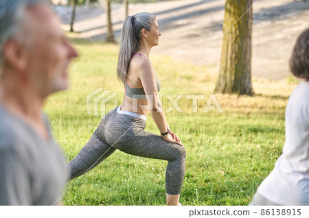 Group of people having a workout and doing lunges together 86138915
