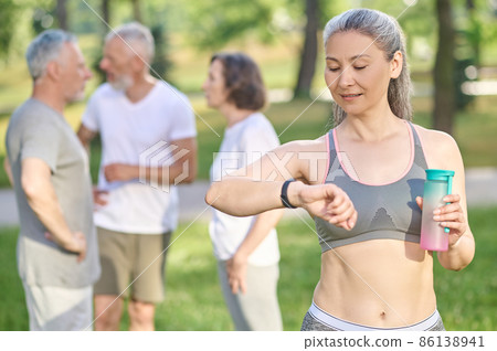 A sporty woman with a bottle of water in hands A sporty woman with a bottle of water in hands 86138941