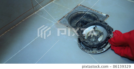 Drain cleaning. Clogged and dirty sewer pipes floor drain. Full of hair and accumulated clogged grease. Maintenance the floor drain sewage system in bathroom. fixing clean wash and unclog a drain. 86139329