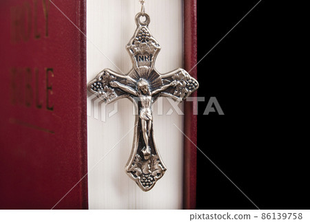 Bible with metal cross isolated on black background Bible with metal cross isolated on black background 86139758