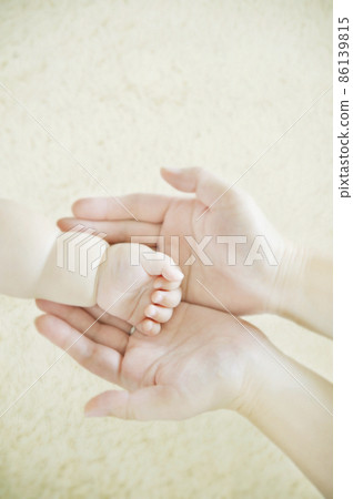 Mother's hand wrapping the baby's hand Mother's hand wrapping the baby's hand 86139815
