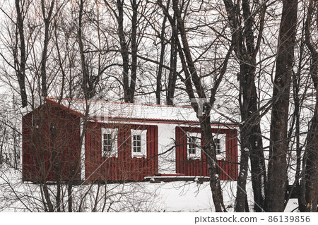 A small red wooden house in the forest 86139856