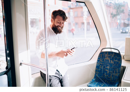 Bearded man using phone in bus 86141125