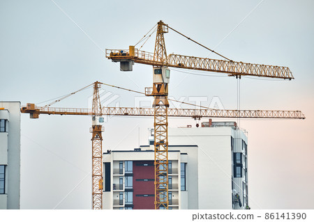 Tower cranes at high residential apartment buildings construction site. Real estate development Tower cranes at high residential apartment buildings construction site. Real estate development 86141390