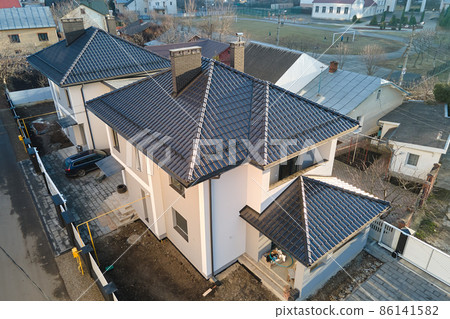 Aerial view of private house with ceramic shingles covered roof top. Investment in real estate concept Aerial view of private house with ceramic shingles covered roof top. Investment in real estate concept 86141582