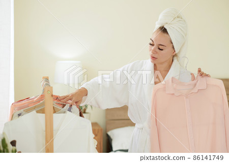 Woman Taking Clothes from Rail 86141749