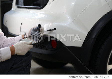 Mechanic installs parking sensors on car closeup Mechanic installs parking sensors on car closeup 86141796