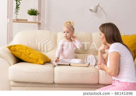 Child with cochlear implants having fun with mother at home. Deafness and medical technology concept. 86141896