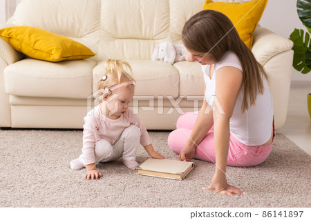 Child with cochlear implants having fun with mother at home. Deafness and medical technology concept. 86141897