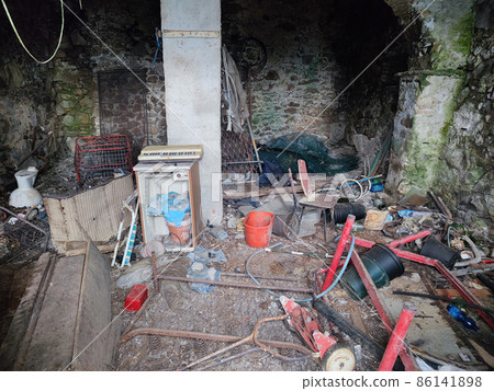 abandoned stone house full of rubbish in italy 86141898