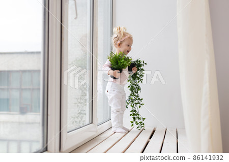 Baby with cochlear implants having fun at home. Deafness and medical technology concept. Baby with cochlear implants having fun at home. Deafness and medical technology concept. 86141932