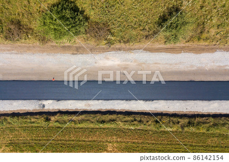 Aerial view of new road construction with newly layed black asphalt lane. 86142154