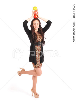 Teen girl holds an three apples on her head Teen girl holds an three apples on her head 86143522