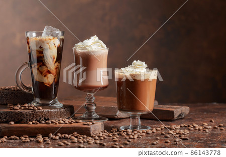 Coffee and chocolate drinks with whipped cream. 86143778