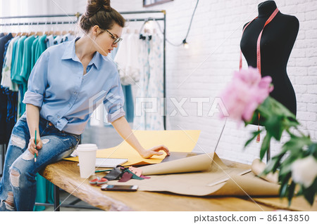 Pensive woman with laptop in atelier Pensive woman with laptop in atelier 86143850