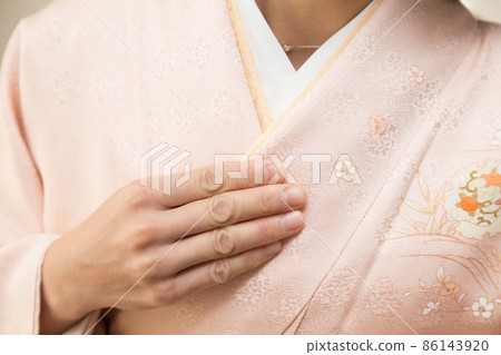 Female hand wearing a kimono Female hand wearing a kimono 86143920