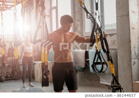Young sporty man getting ready for workout in the gym Young sporty man getting ready for workout in the gym 86144657