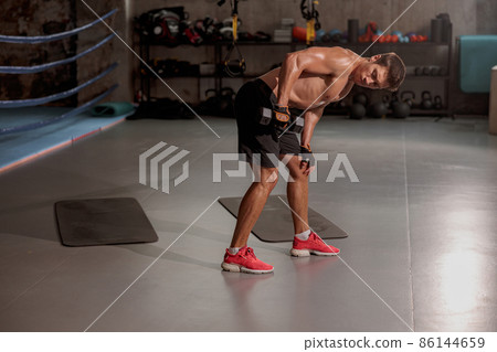 Young man doing sports arm exercise in the gym Young man doing sports arm exercise in the gym 86144659