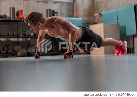 Young sporty man exercising actively in the fitness club Young sporty man exercising actively in the fitness club 86144660