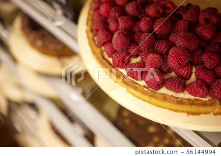 Tart with raspberries and whipped cream decorated with mint leaves. Tart with raspberries and whipped cream decorated with mint leaves. 86144994