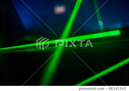 Bright green neon laser lights illuminate the darkness creating lines and triangle shapes in sci-fi effect. 86145341