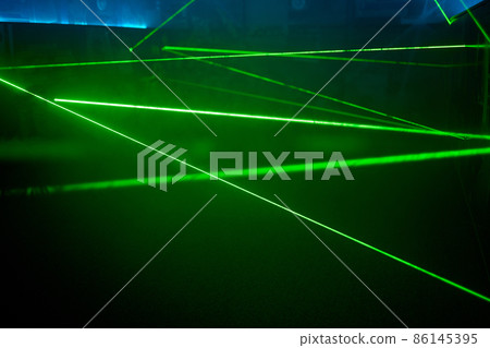 Bright green neon laser lights illuminate the darkness creating lines and triangle shapes in sci-fi effect. 86145395
