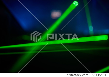 Bright green neon laser lights illuminate the darkness creating lines and triangle shapes in sci-fi effect. 86145491