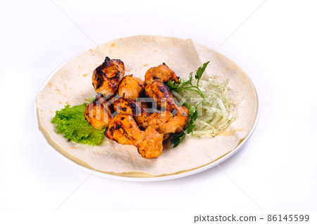 Chicken meat on pita bread with vegetables on a white plate on a white isolated background Chicken meat on pita bread with vegetables on a white plate on a white isolated background 86145599