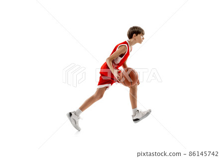 Full-length portrait of basketball player in motion, dribbling ball, training isolated over white studio background 86145742
