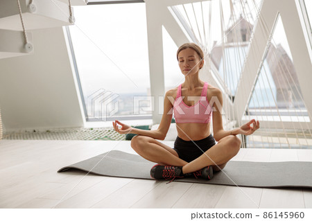 Pretty young woman is practicing home yoga Pretty young woman is practicing home yoga 86145960