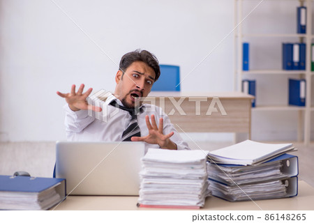 Young male employee and too much work in the office 86148265