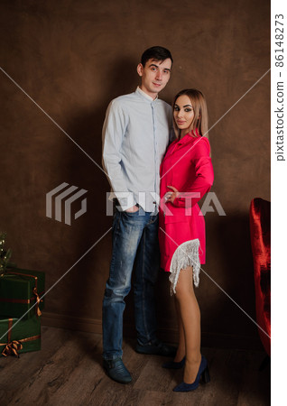 A girl in a beautiful pink dress hugs a man in a shirt and trousers A girl in a beautiful pink dress hugs a man in a shirt and trousers 86148273