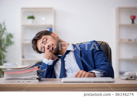 Young male employee extremely tired in the office 86148274