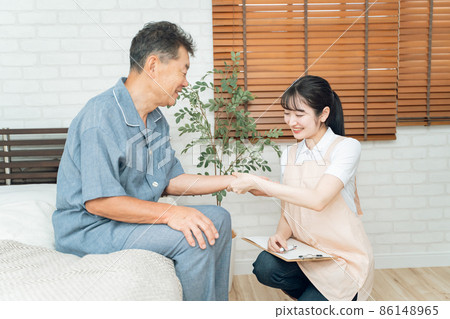 Female staff measuring the pulse of elderly men Female staff measuring the pulse of elderly men 86148965