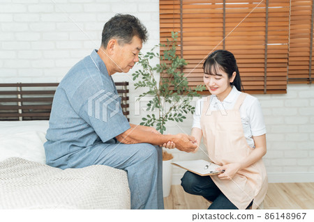 測量老年男性脈搏的女性工作人員 86148967