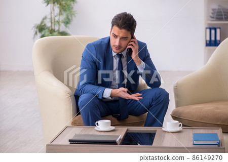 Young male employee waiting for business meeting Young male employee waiting for business meeting 86149270