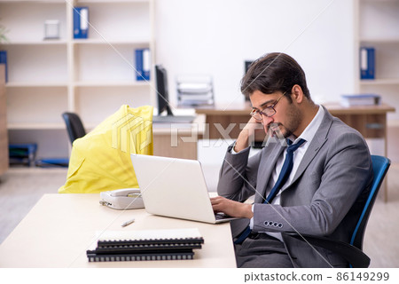 Young male employee looking after new born at workplace 86149299
