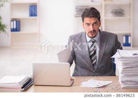 Young male employee unhappy with excessive work in the office 86149623