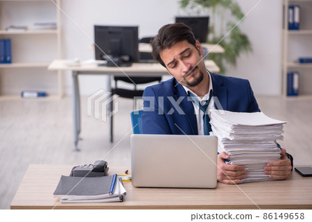 Young male employee unhappy with excessive work in the office 86149658