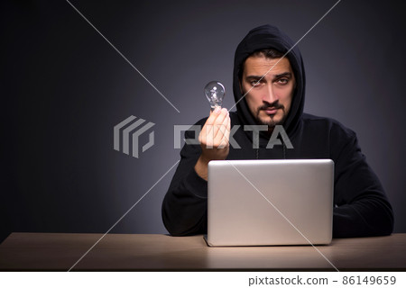 Young male hacker on grey background Young male hacker on grey background 86149659
