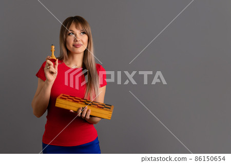 Woman chess player holding chessboard 86150654