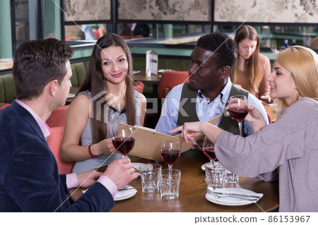 Happy people discussing restaurant menu Happy people discussing restaurant menu 86153967